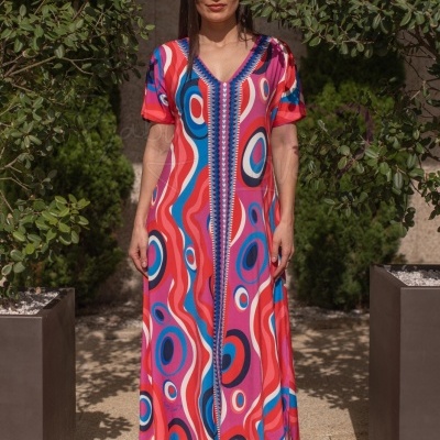 Vestido comprido colorido com padrão geométrico e sandálias vermelhas ao ar livre