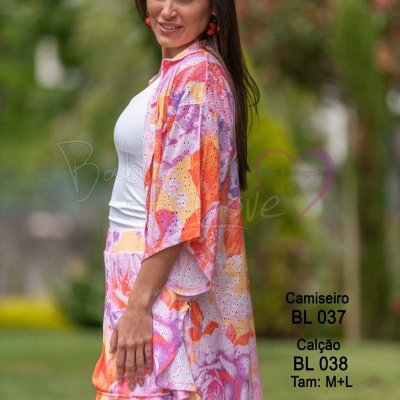 Conjunto feminino com camisa e calção em padrão floral roxo, laranja e branco ao ar livre
