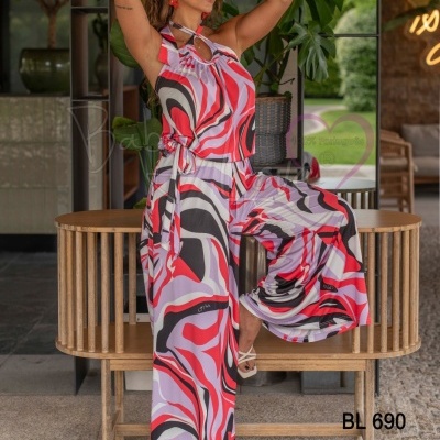 Macacão feminino colorido com padrão abstracto e salto branco, modelo numa ambiente interior