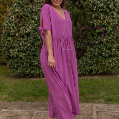 Vestido comprido rosa vibrante com decote em V e laços nas mangas usado ao ar livre