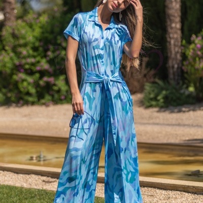 Macacão azul feminino com padrão abstrato e cinto, usado por mulher em jardim