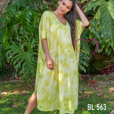 Vestido comprido verde claro com padrão tie-dye e ténis brancos em jardim