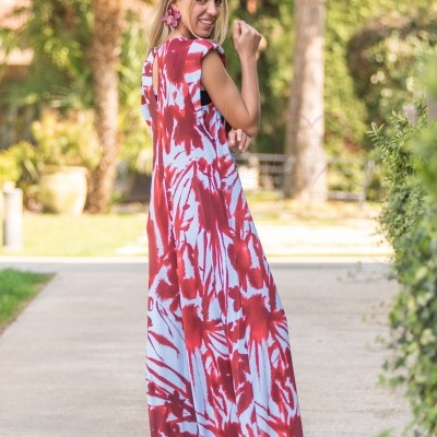 Vestido largo vermelho e branco com padrão tie-dye e abertura nas costas ao ar livre