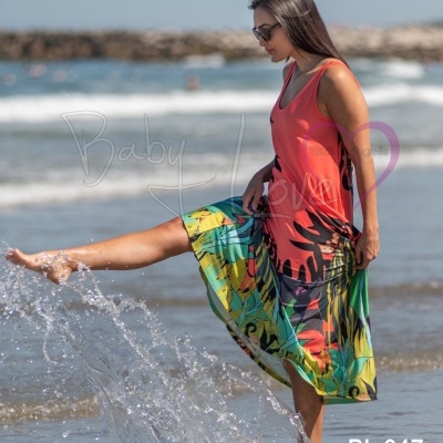 Mulher de vestido colorido na praia a brincar com água