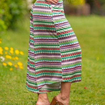 Calças culotte coloridas com padrão geométrico em modelo feminino ao ar livre