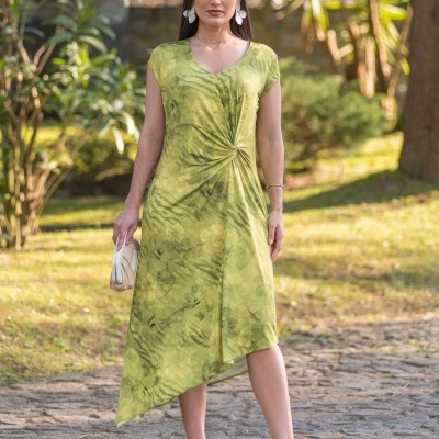 Vestido assimétrico verde com padrão floral com nó frontal em ambiente exterior