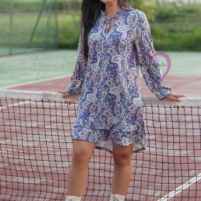 Vestido curto de manga comprida com padrão floral azul e lilás num campo de ténis