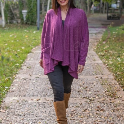 Mulher a usar camisola cardigan roxa com leggings pretos e botas castanhas, num caminho ao ar livre.