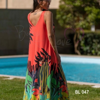 Vestido comprido laranja com padrão folhagem colorida junto à piscina