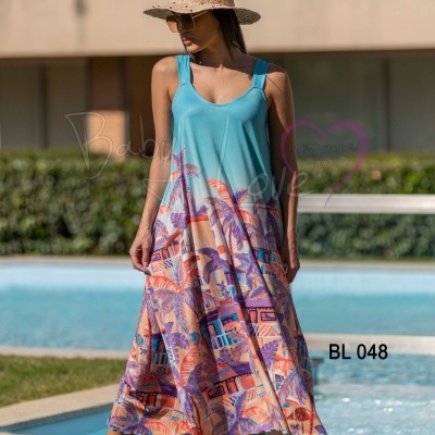 Vestido longo azul-turquesa com padrão colorido e chapéu de palha junto a piscina