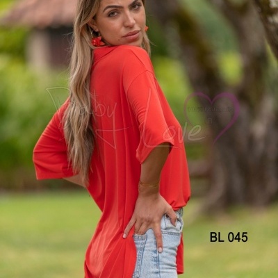 Blusa vermelha de manga 3/4 com calças de ganga em ambiente exterior