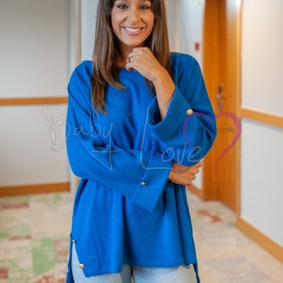 mulher com camisola azul de malha canelada e calças de ganga claras