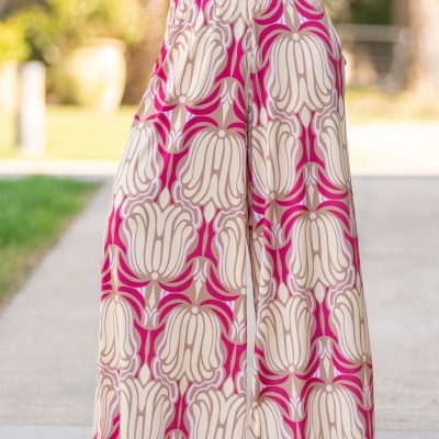 Pantalonas compridas com padrão floral em tons de bege e rosa, usadas ao ar livre.