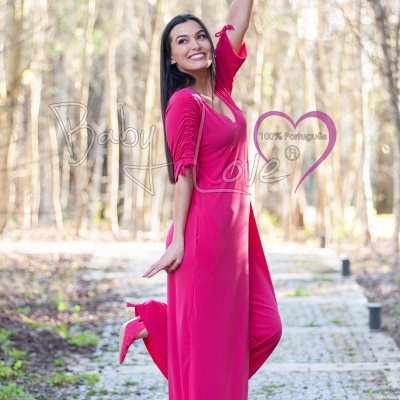 Mulher com macacão rosa e sapatos de salto, em caminho de pedra ao ar livre