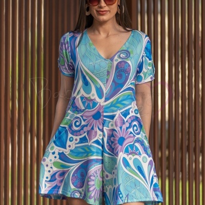 Vestido curto de padrão floral colorido com mulher a usar óculos de sol castanho