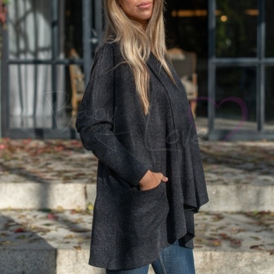 Mulher com casaco cinza escuro, jeans azul e botas pretas ao ar livre