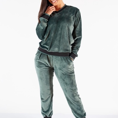 Conjunto desportivo feminino em veludo verde-escuro com punhos e bainha pretos, camisola e calças, botas castanhas