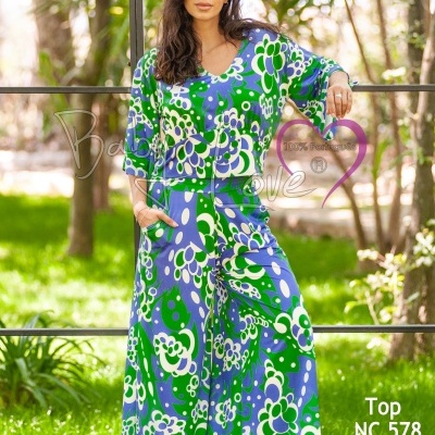 Mulher com conjunto de top e pantalona floral colorido em ambiente exterior