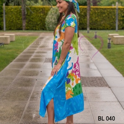 Mulher a usar vestido longo colorido com lenço a condizer em ambiente exterior pavimentado e jardim