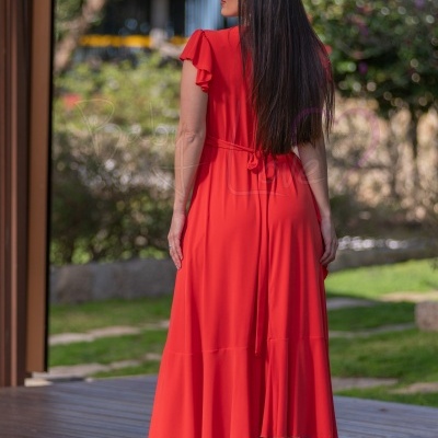 Vestido vermelho longo com mangas curtas folhadas e sapatos de salto transparentes ao ar livre