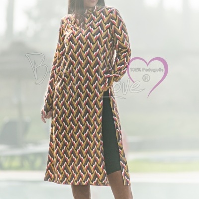 Vestido comprido com padrão geométrico colorido e botas castanhas altas em ambiente exterior