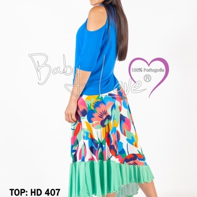 Mulher com top azul e saia colorida em fundo branco
