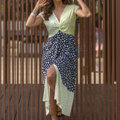 Vestido midi estampado com decote em V e nó, usado por mulher com óculos escuros e sandálias pretas.