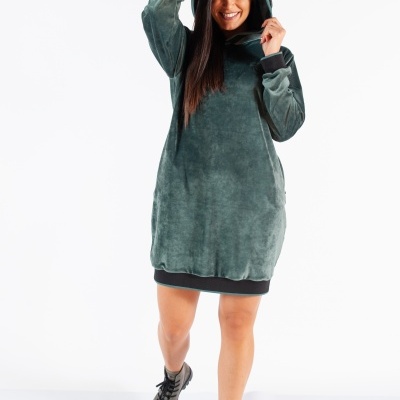 Vestido hoodie verde felpudo com punhos e bainha pretos, mulher sorridente com botas pretas em fundo branco