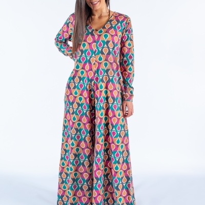 Vestido longo colorido com padrão geométrico usado por mulher em fundo branco