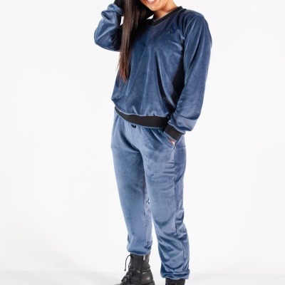 Fato de treino azul aveludado com botas pretas em fundo branco