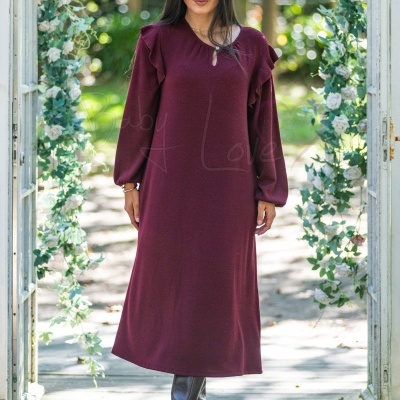 Vestido comprido vinho com folhos, usado por mulher em ambiente exterior com porta floral