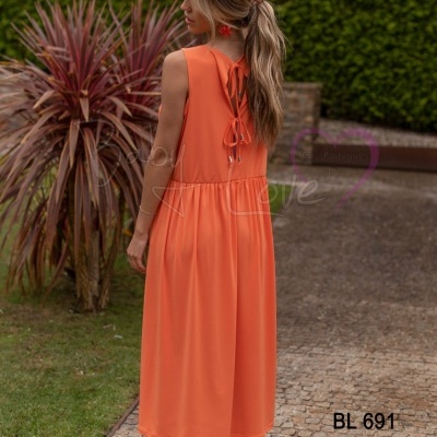 Vestido laranja midi feminino com alças e laços nas costas em ambiente exterior