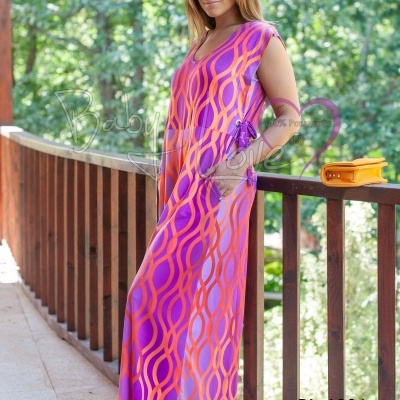 Vestido longo rosa e laranja com padrão geométrico numa varanda