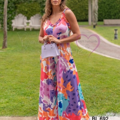 Vestido longo colorido com padrões abstratos em ambiente de jardim