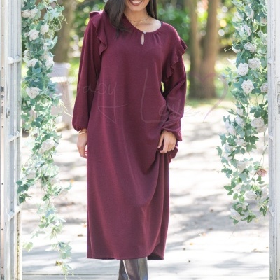 Vestido vinho com folhos e botas pretas ao ar livre com flores brancas