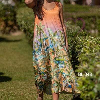 Vestido comprido laranja com padrão tropical e alças largas em ambiente exterior
