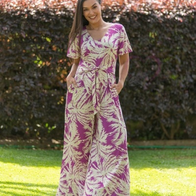 Macacão feminino roxo e creme com padrão de folhas, cinto e sapatos bege ao ar livre