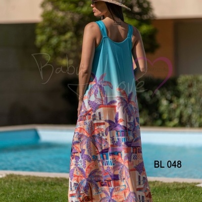 Vestido comprido azul turquesa com padrão de praias e palmeiras, usado ao ar livre junto a piscina