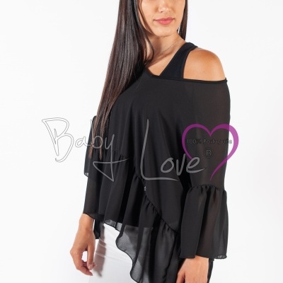 Mulher vestindo blusa preta assimétrica com folhos, calças brancas e faixa de cabeça azul em fundo branco