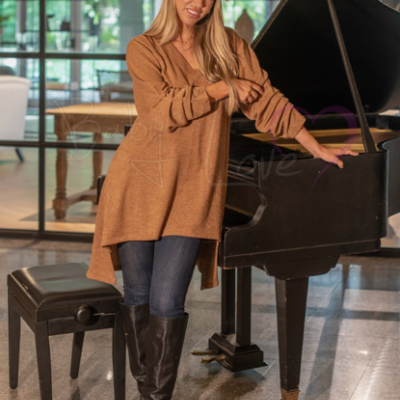 Mulher com roupa de outono junto a piano preto