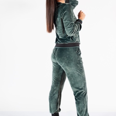 Pessoa de costas usando fato de treino verde escuro aveludado com detalhes pretos e botas castanhas.