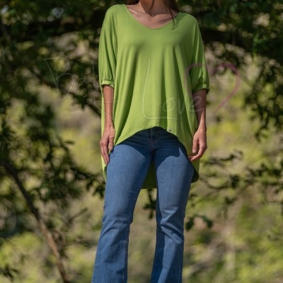 mulher vestindo túnica verde e calças de ganga azuis em ambiente natural