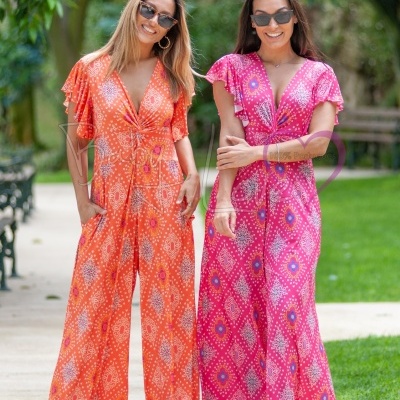 Duas mulheres usam macacões coloridos com padrão geométrico e óculos de sol ao ar livre