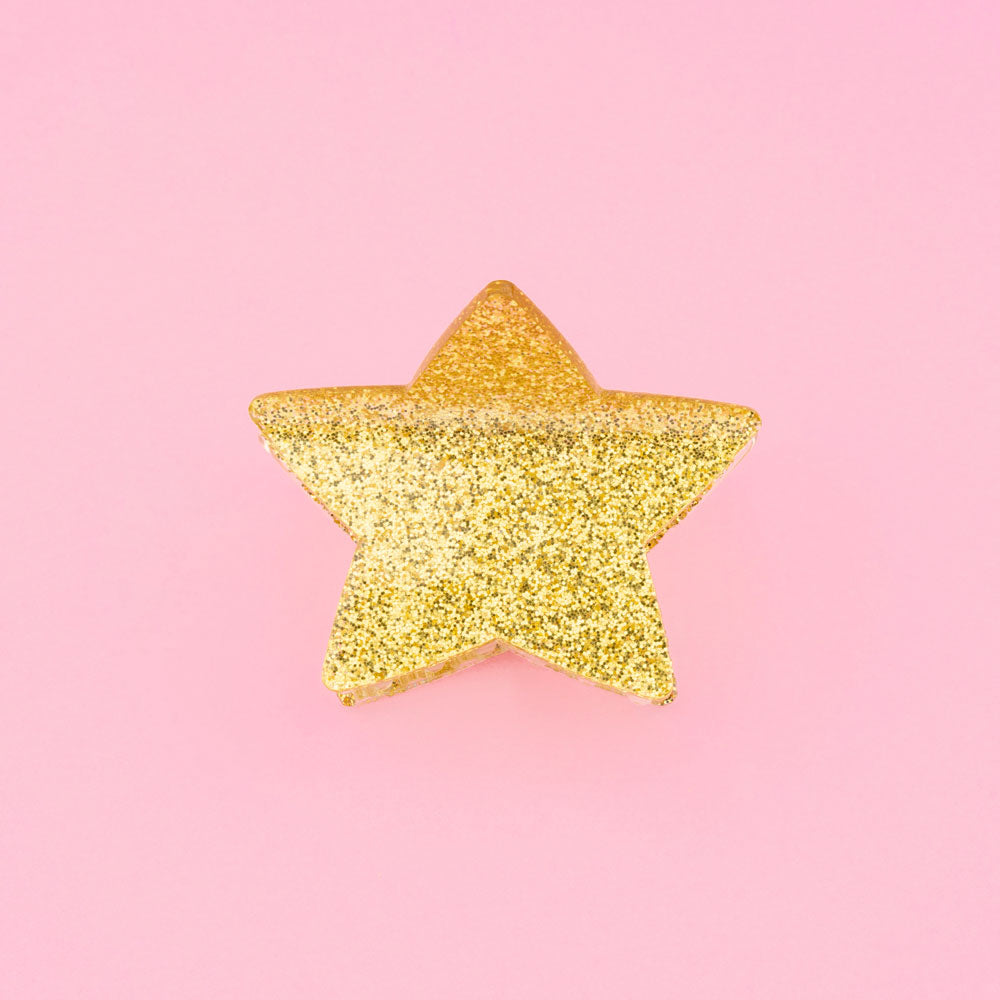 Estrela decorativa dourada com glitter em fundo rosa
