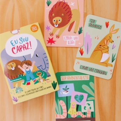 Conjunto de cartas educativas com mensagens motivacionais sobre mesa de madeira