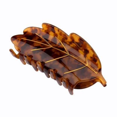 Presilha de cabelo em forma de folha castanha com padrão manchado e detalhes dourados.