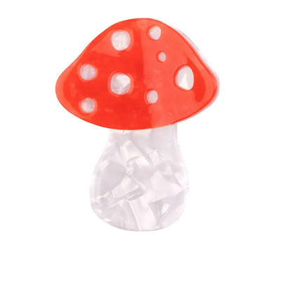 Objeto decorativo em forma de cogumelo vermelho com pontinhos brancos e caule branco translúcido