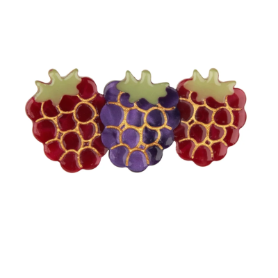 Broche em forma de bagas vermelhas e roxa com detalhes dourados e folhas verdes.