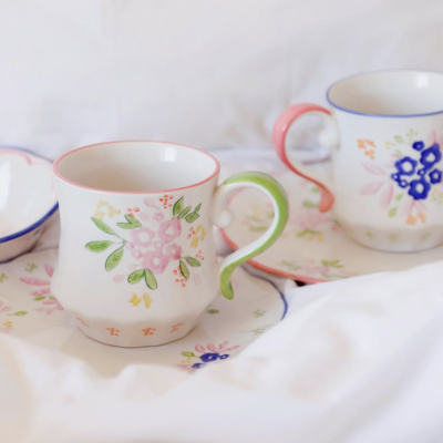 Duas chávenas de porcelana floral com pires em fundo branco