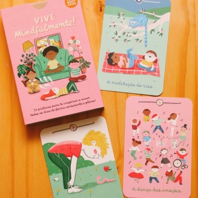 Cartas ilustradas coloridas para mindfulness com caixa rosa e textos em português sobre madeira clara.